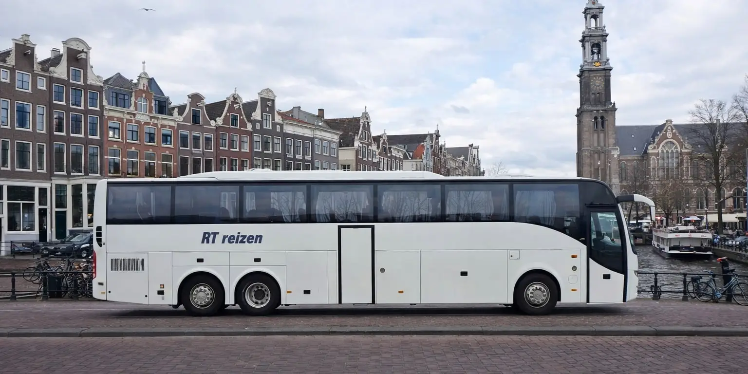 Touringcar van RT Reizen, geparkeerd aan een gracht.